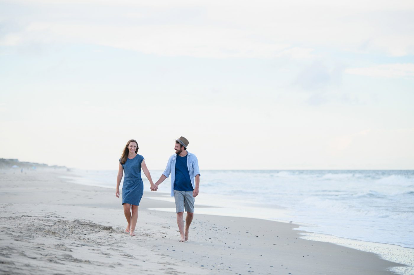 Couple walking together on the beach during a family portrait session in Corolla
