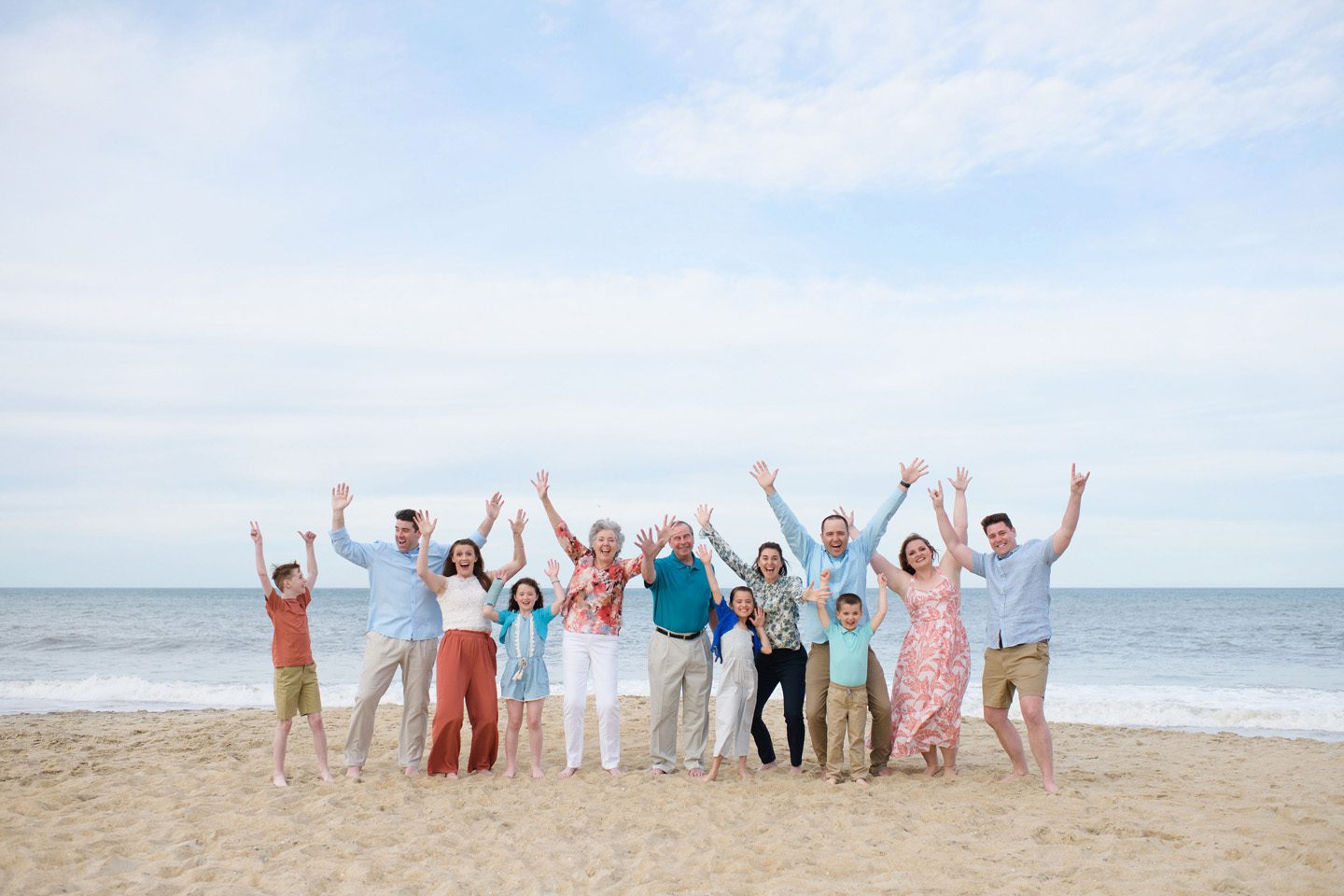A family portrait on the Outer Banks featuring a large group wearing a mix of colors and patterns